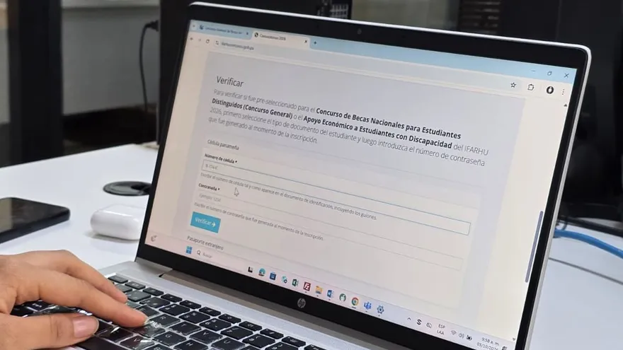 Students in Panama reviewing scholarship application paperwork or checking an online registration portal