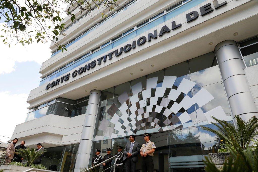 A transgender pride flag draped over a courthouse or legal building in Ecuador