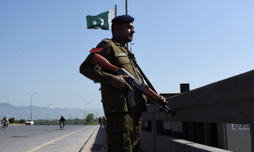 Diplomats meeting across a переговор table with flags in the background amid Middle East ceasefire talks