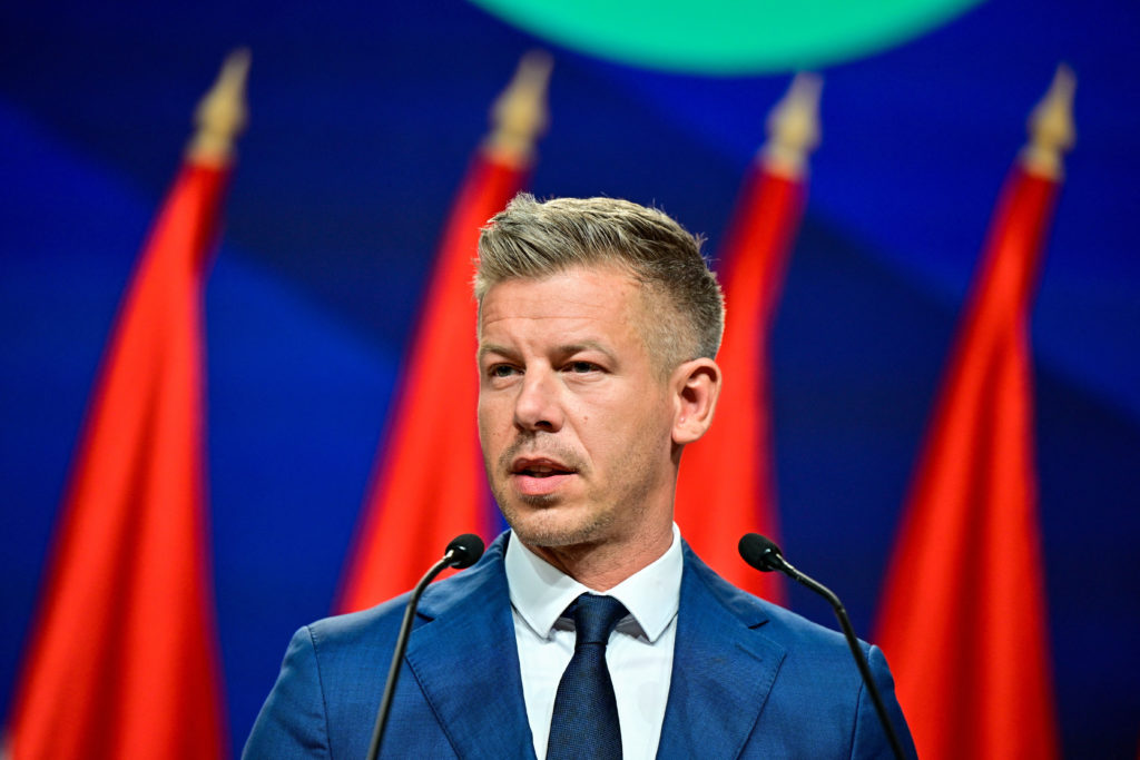 Péter Magyar speaking at a podium after winning Hungary's election, with European Union and Ukrainian flags in the background