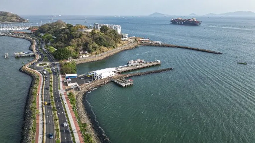 People walking along Calzada de Amador in Panama City with waterfront views and vendor activity nearby