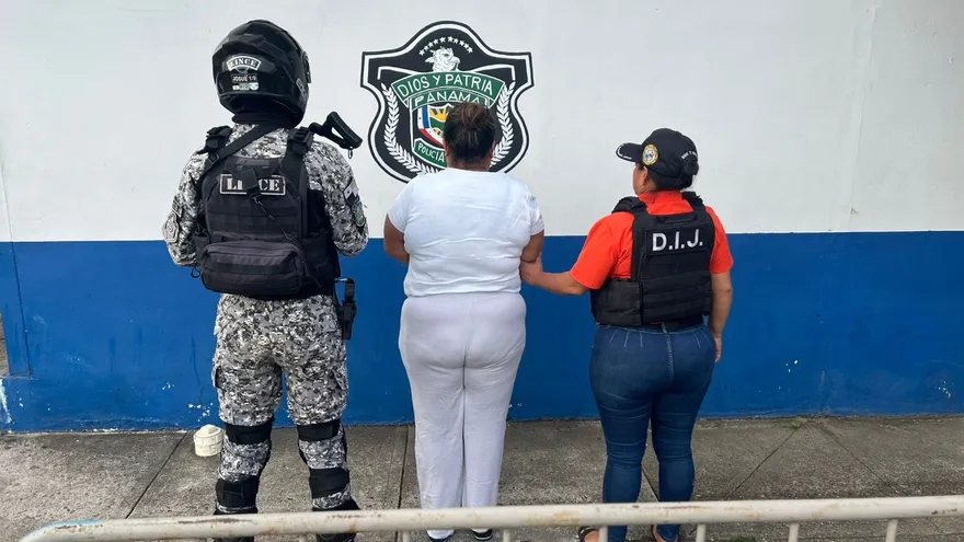Police officers escorting a detained woman in Arraiján after an arrest linked to aggravated theft