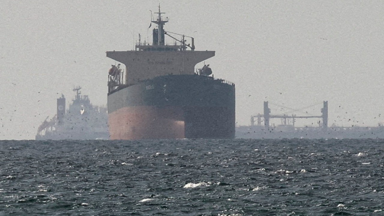 Oil tanker ships near a narrow maritime strait with market charts in the background