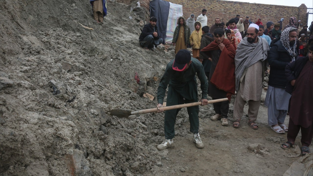 Rescue workers and residents near damaged homes after an earthquake in Afghanistan