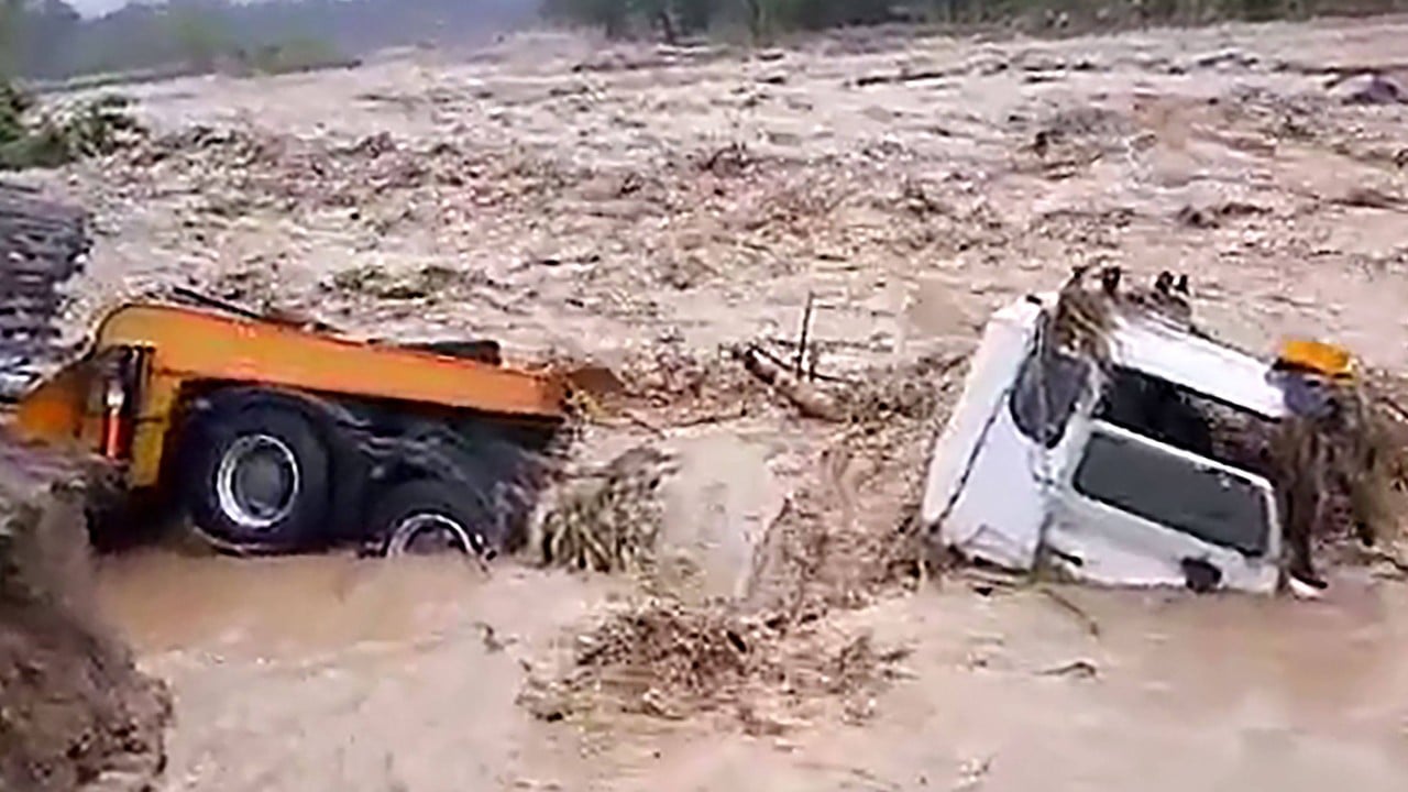 Rescue workers and residents assessing cyclone damage in a flooded Pacific island community