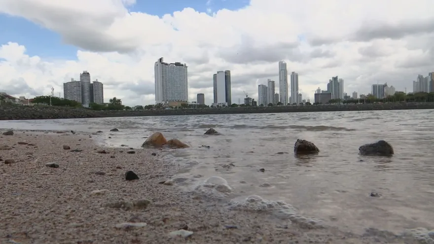 Cloudy skies over Panama with a coastal Caribbean scene and a bright sun indicating high ultraviolet radiation