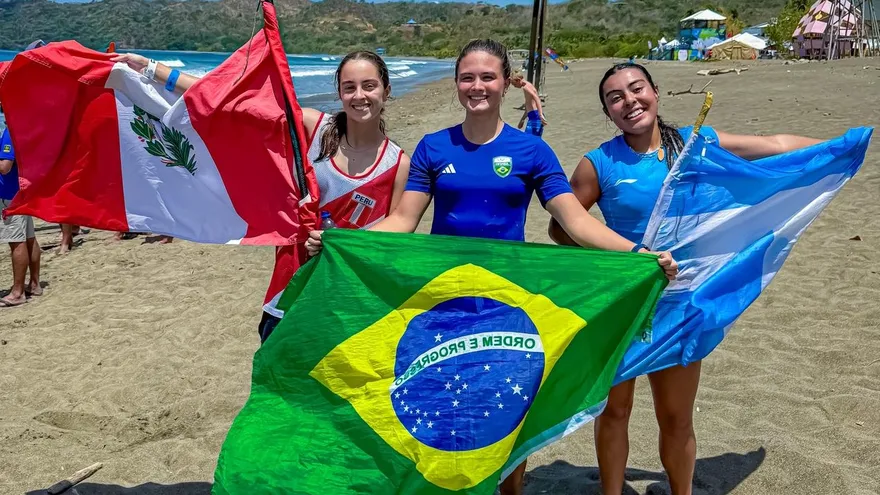 Young athletes competing in a multi-sport event in Panama with national flags and a medal standings board in the background