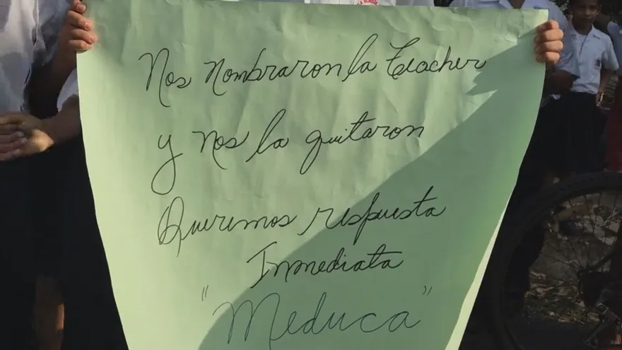 Parents and schoolchildren outside a bilingual school in Los Santos discussing the lack of an English teacher