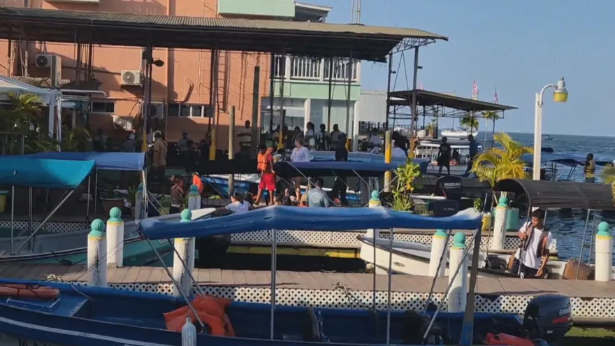 Maritime inspectors monitoring a busy dock in Bocas del Toro as tourists arrive during Holy Week