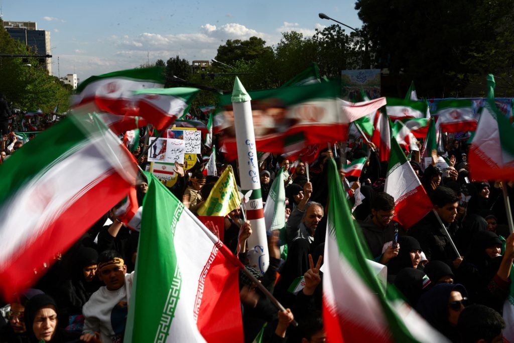 People in Tehran walking past a street scene amid tension and uncertainty in Iran