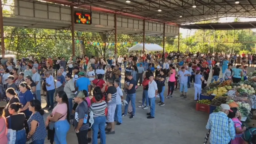Shoppers selecting bags of rice at a busy agrofair in Dolega, Panama