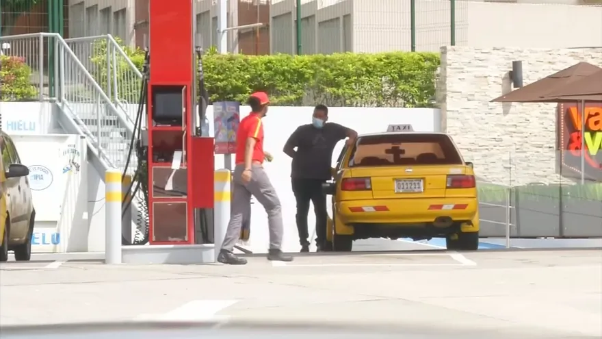 Transport operators reviewing a government fuel subsidy registration guide on a computer or phone in Panama