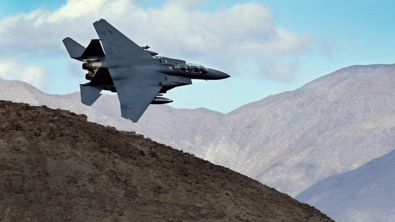 A U.S. fighter jet and rescue aircraft flying in a tense military operation
