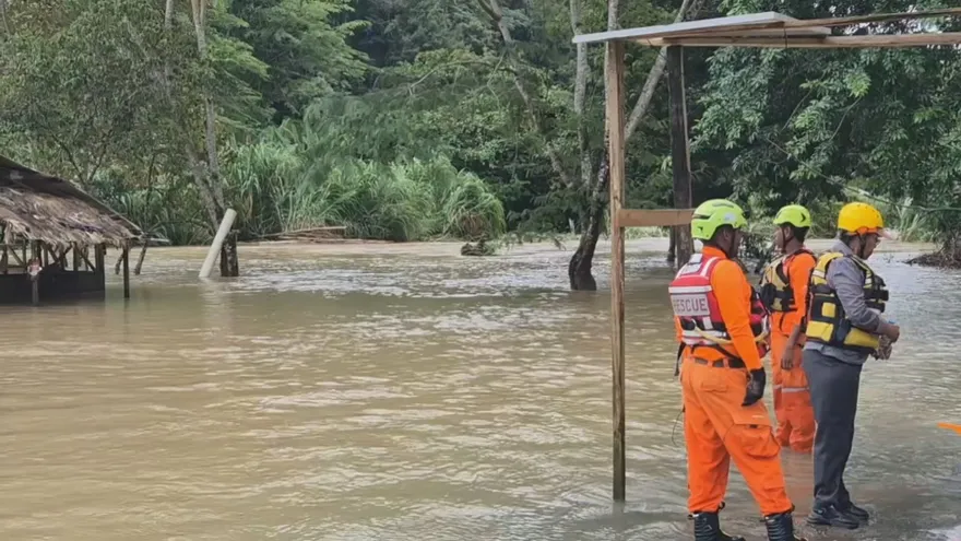 Emergency crews navigating a muddy rural road in Panama during heavy rainfall