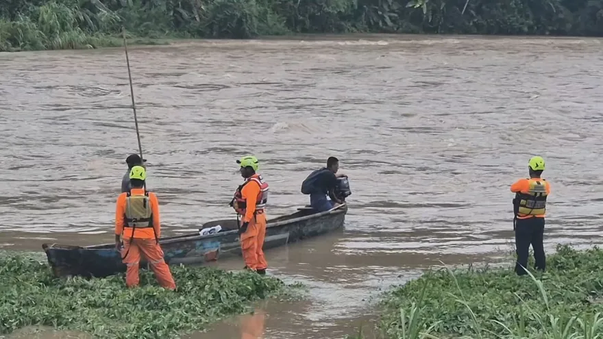 Flooded rural area in Veraguas after heavy rain, with swollen river and damaged surroundings