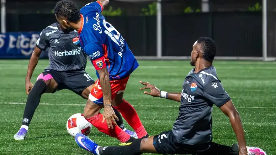 Soccer players competing in a Liga Panameña de Fútbol match on a green pitch in Panama