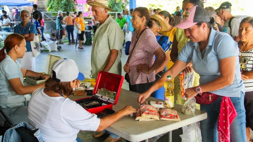 Shoppers browsing low-cost produce and basic food items at an IMA agro fair in Panama
