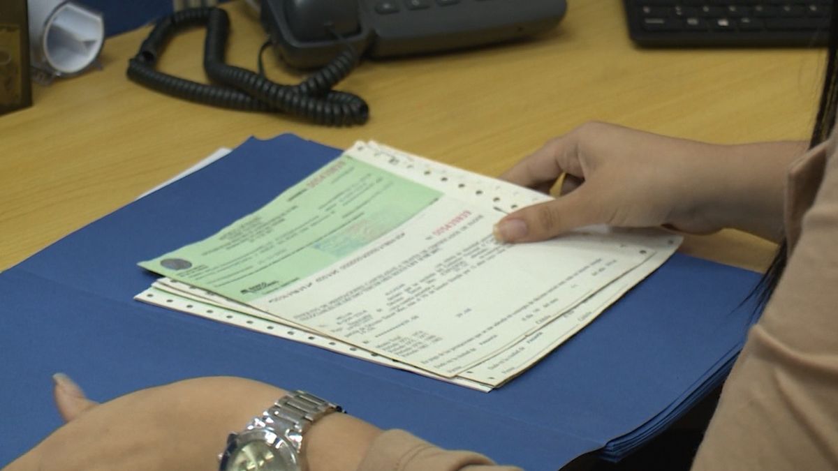 A beneficiary checking an official government payment list at a public office in Panama