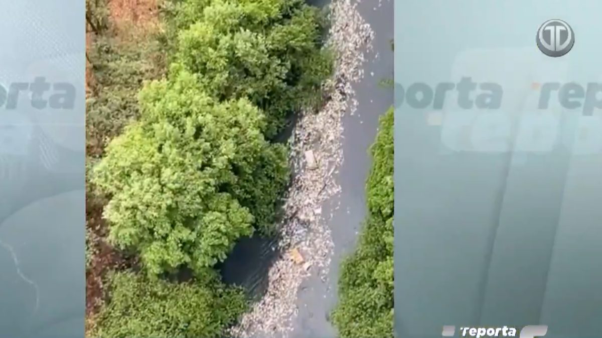 Trash and debris carried by floodwater from an urban river mouth into the sea in Panama City