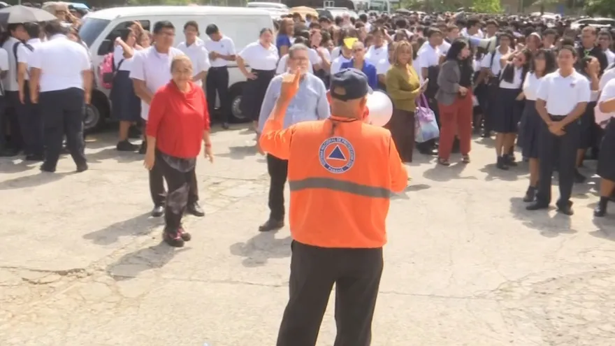 Students and teachers practicing an evacuation drill outside a school building in Panama