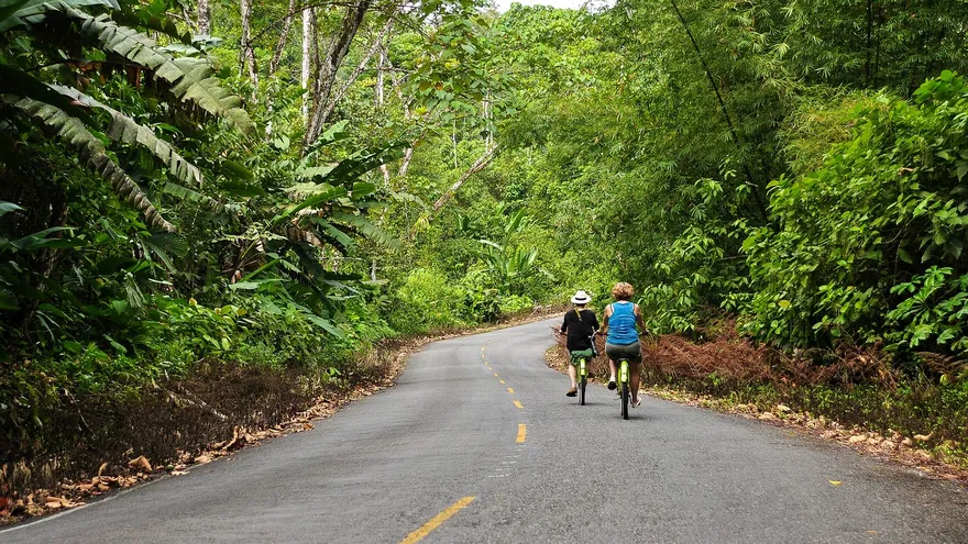 Travelers at an airport in Panama, with luggage and departure signs in the background