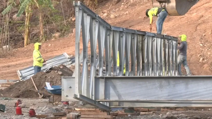 A rural bridge under construction in the Ngäbe Buglé comarca with mountainous terrain in the background