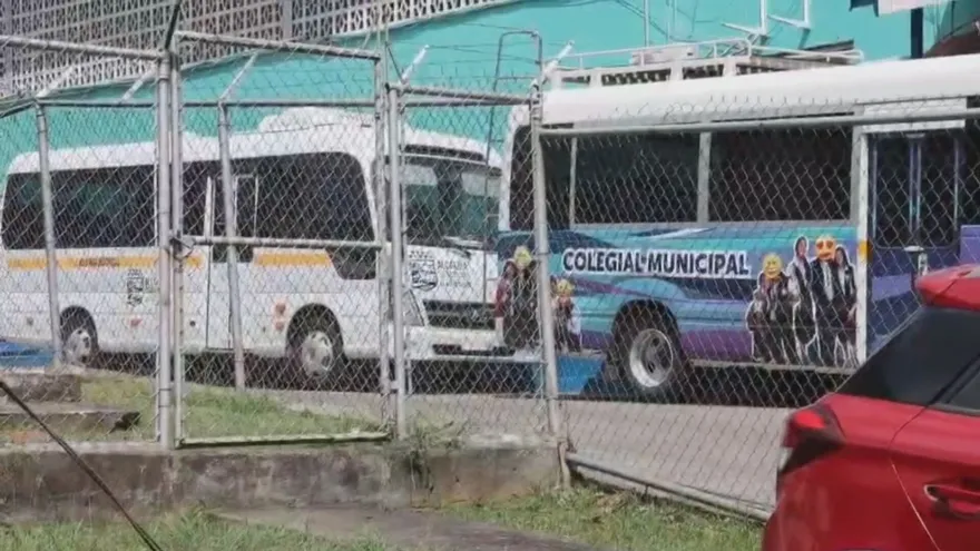 Municipal buses in Arraiján with political stickers covering an official mayoral image