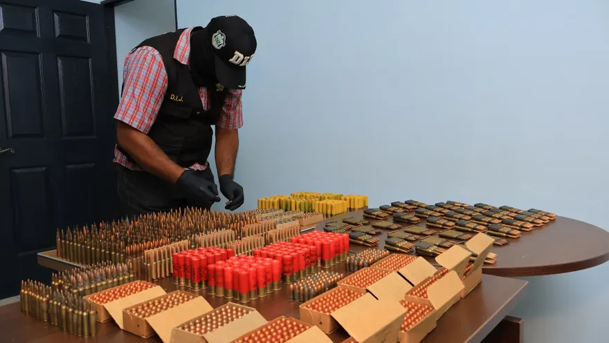 Police officers inspecting a hidden weapons cache with ammunition and grenades in Vacamonte, Arraiján