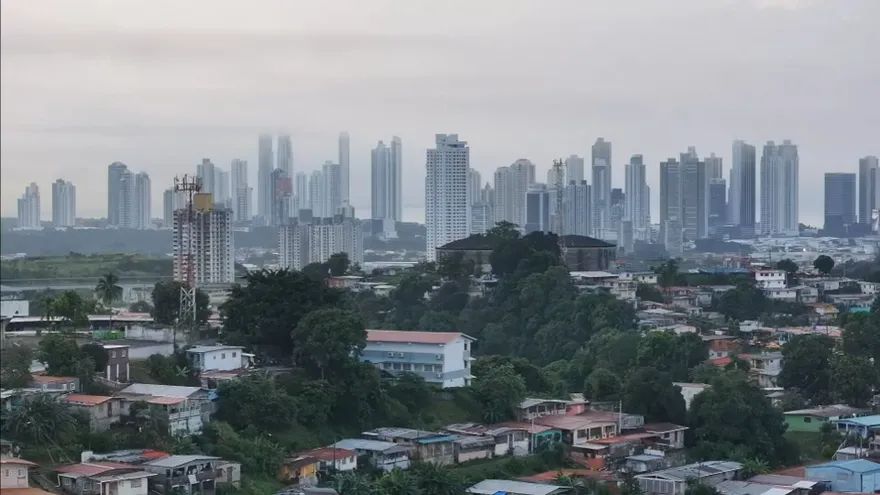 Dark storm clouds over a rainy street in Panama with people carrying umbrellas