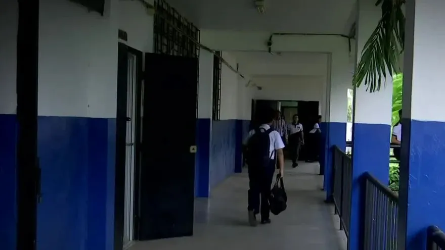 Teachers, parents, and local authorities discussing school security measures outside a school in San Miguelito, Panama.