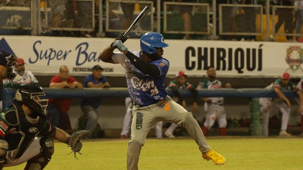 Baseball players on a Panama field during a Béisbol Mayor playoff game with fans in the stands