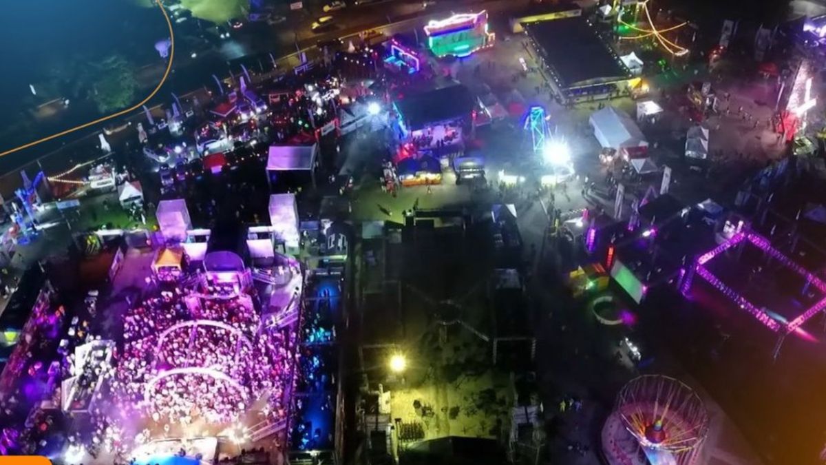 Families and visitors enjoying amusement rides and food stalls at a fair in Panama City