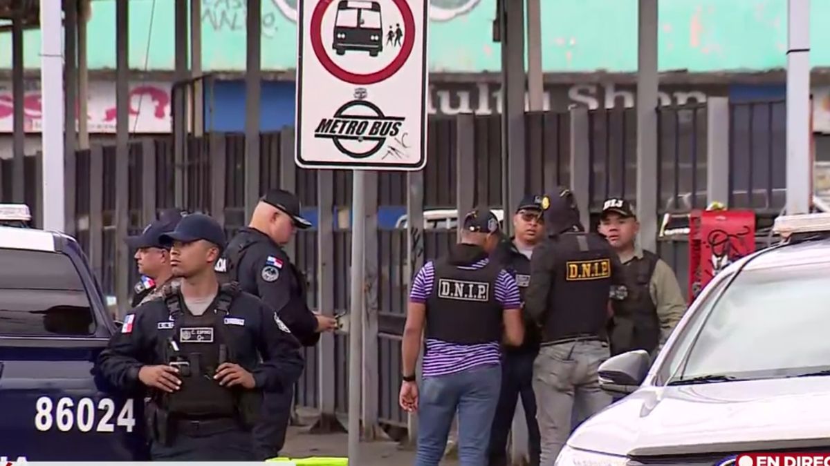 Police officers patrolling a busy street near the Mercado del Marisco in Panama City after a homicide