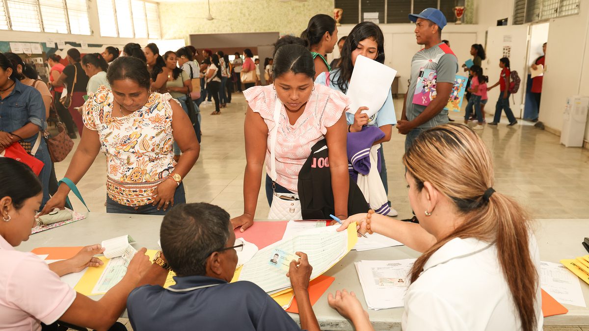 Students in Panama standing outside a school while families prepare scholarship documents for IFARHU
