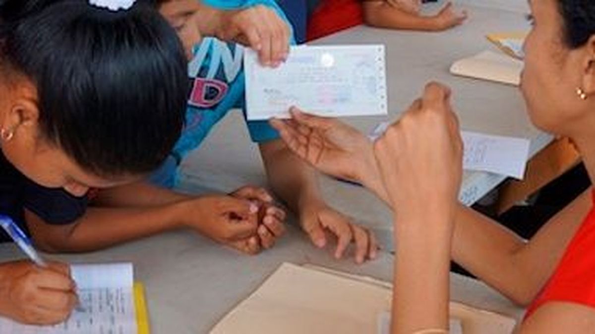 Students and parents waiting in line to submit scholarship documents at an IFARHU office in Panama