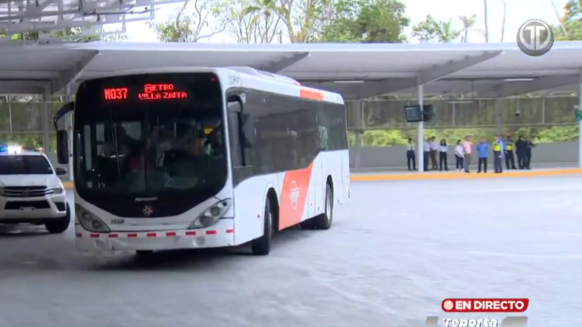 Commuters near a Metro de Panamá interchange in Panama City with buses and transit infrastructure in the background