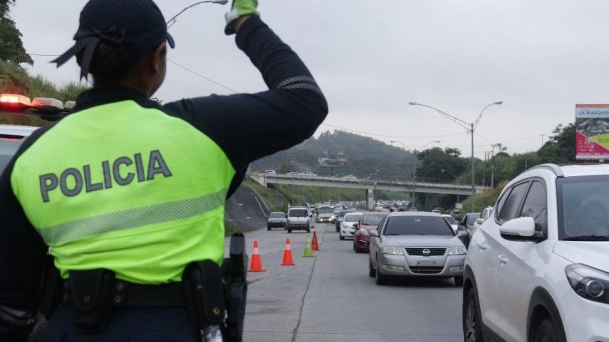 Cars traveling on a major highway in Panama during a holiday traffic operation with traffic control signs in place