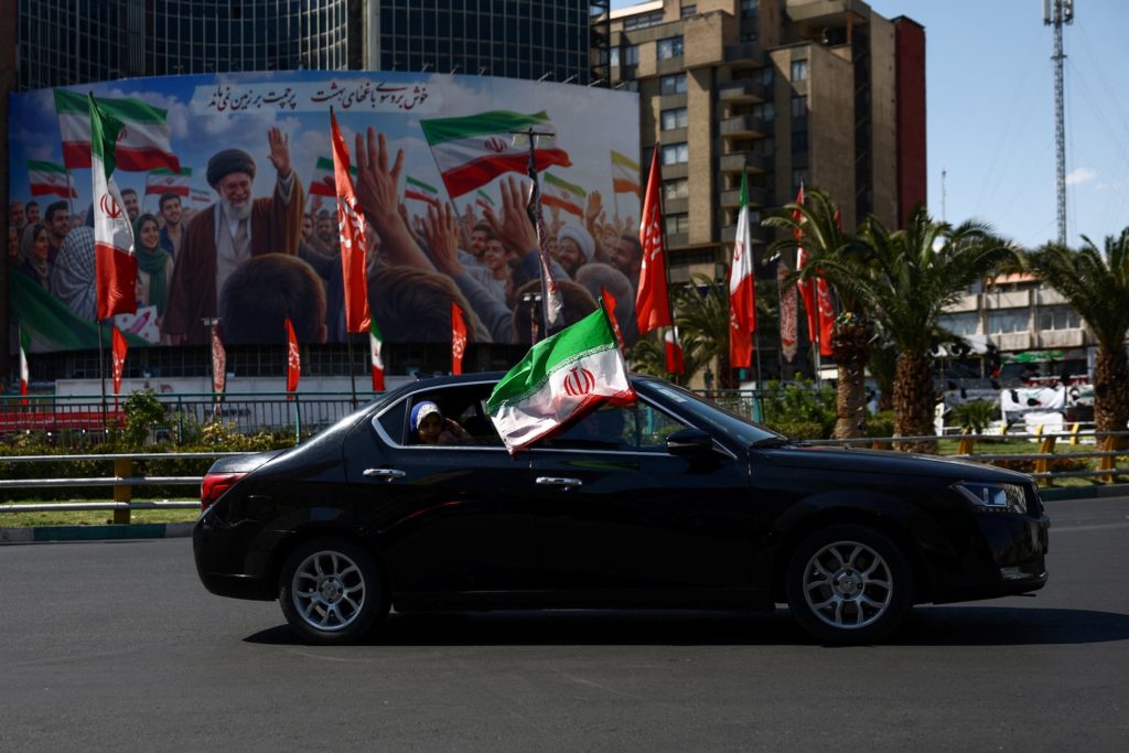 Vice President JD Vance speaking at a diplomatic meeting with flags in the background