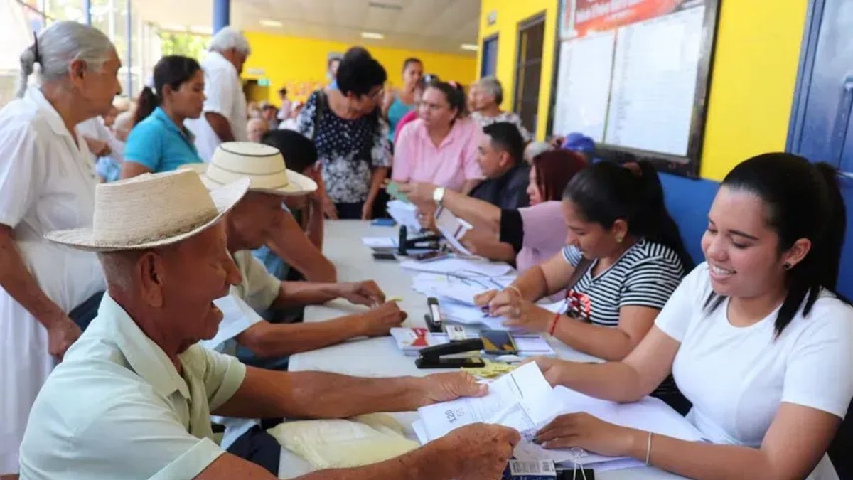 Retirees and pensioners waiting in line or reviewing payment information at a Social Security office in Panama