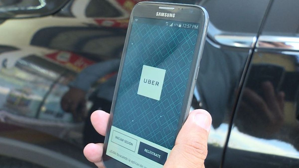 A smartphone showing a ride-hailing app in a city street scene in Panama City, Panama