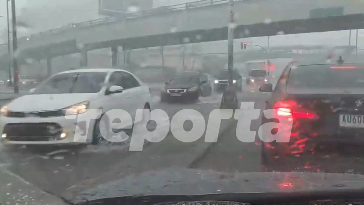 Vehicles moving slowly through a flooded roadway in Panama City during heavy rain