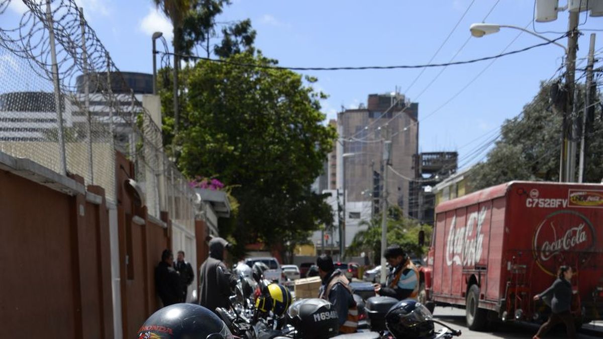 Motorcycle delivery riders waiting near a busy street in Panama City during a labour dispute over platform work