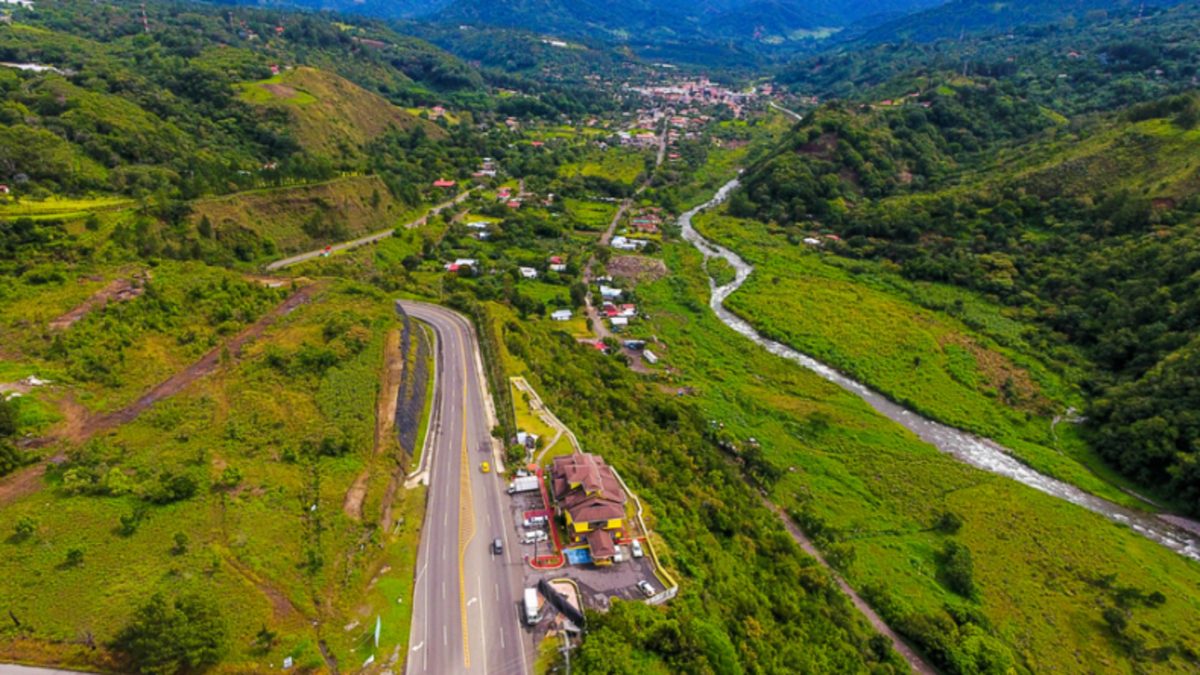A quiet street in Boquete, Chiriquí, with municipal signage and green mountain scenery in the background