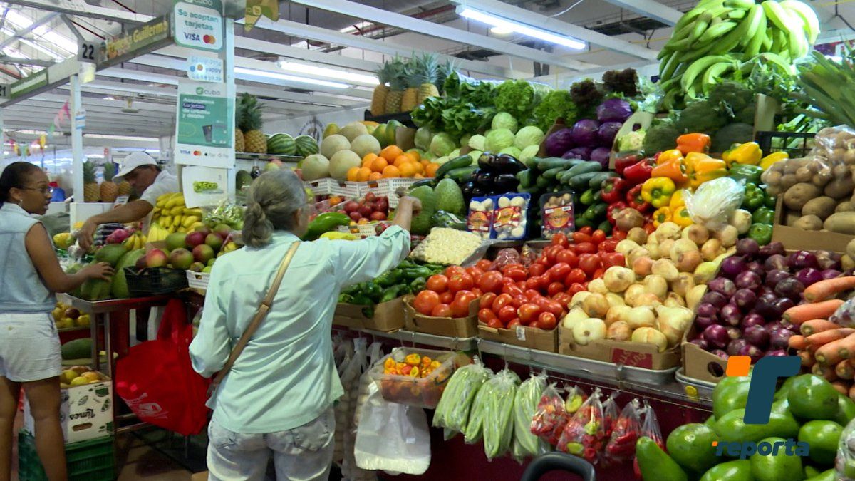Vendors selling tomatoes and other fresh produce at a market in Panama City