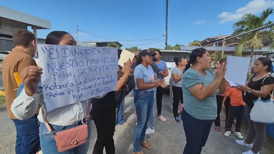 Parents speaking outside a school in Penonomé, Panama, concerned about alleged irregular handling of insurance funds