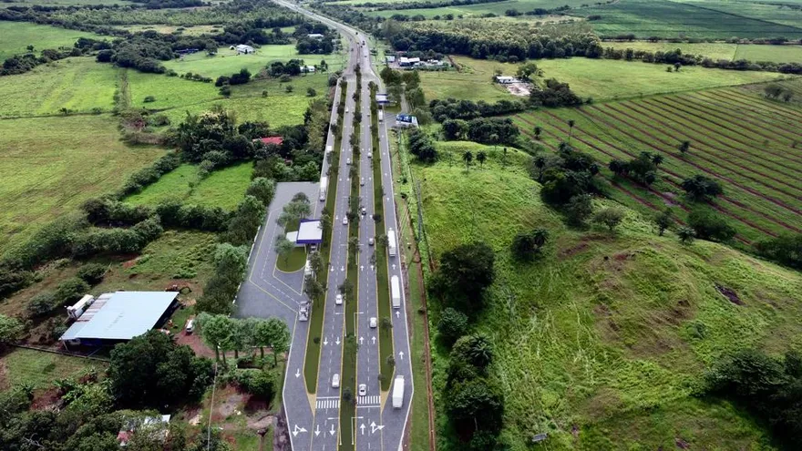 Vehicles traveling along the Pan-American Highway in Panama with roadwork activity and highway signage visible