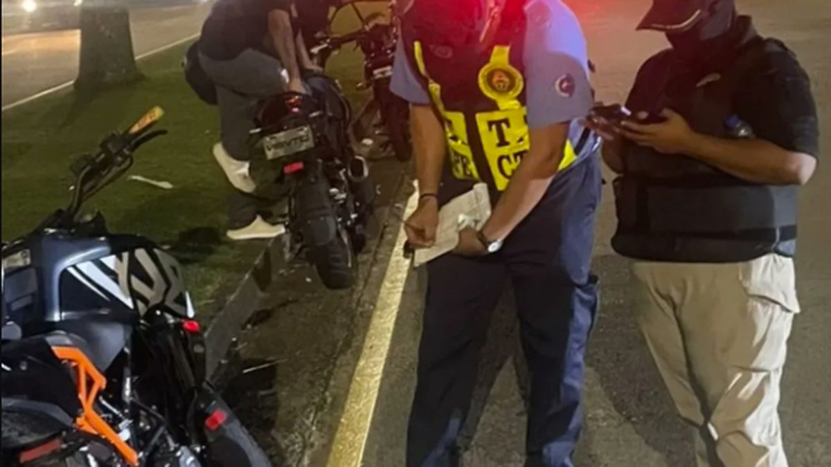 Traffic officers inspecting motorcyclists during an enforcement operation on a road in Panama Oeste