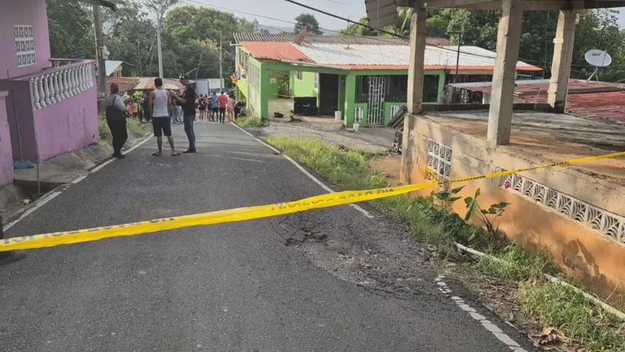Police tape and a street scene in Colón, Panama, following a violent incident involving a teenager