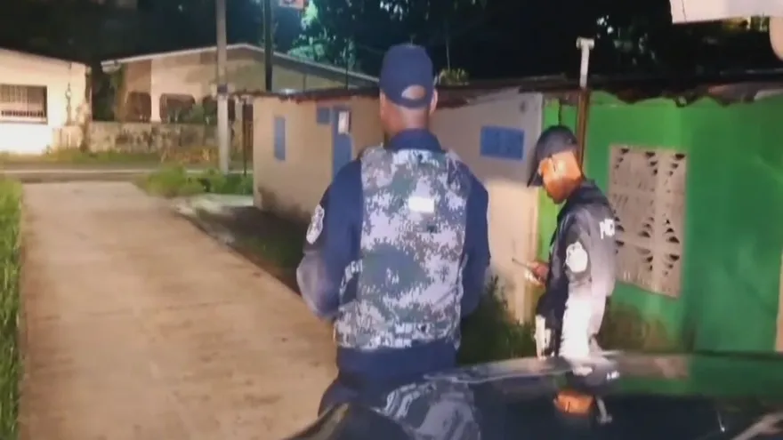 Police officers monitoring a checkpoint on a road in Colón, Panama