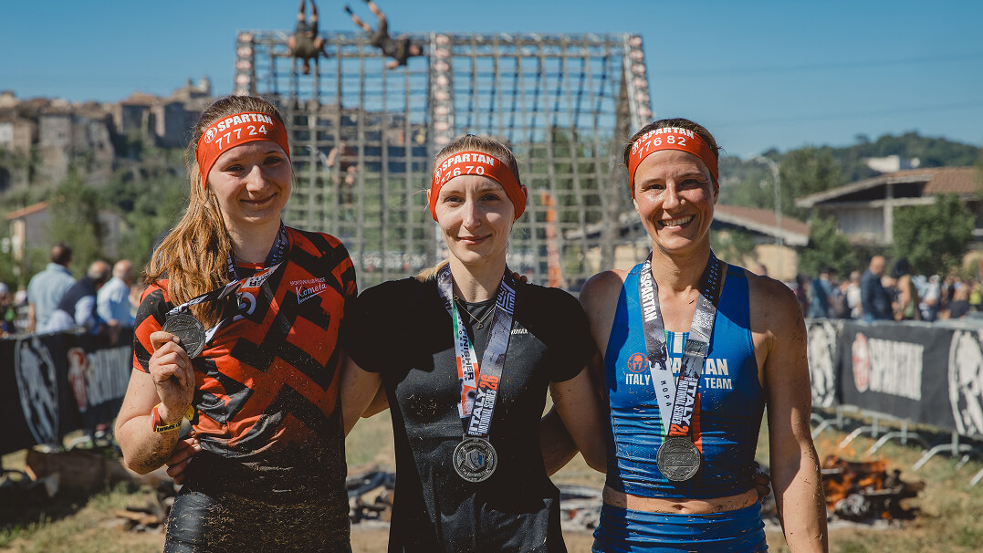 Athletes climbing, crawling and carrying obstacles on an outdoor Spartan Race course at Autódromo Panamá in Chame
